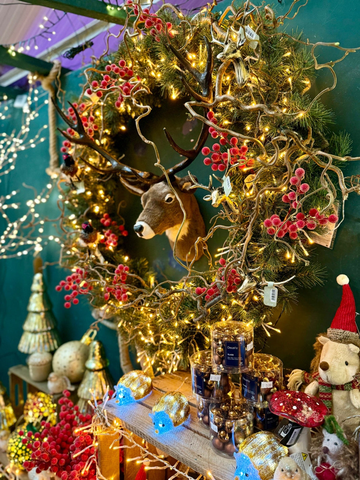 Woodland Christmas wreath and deer display with red berries and warm lights