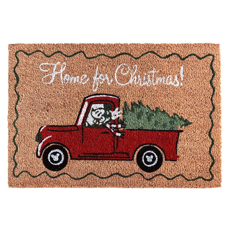 Doormat with a red truck carrying a Christmas tree and 'Home for Christmas!' text on a beige background.